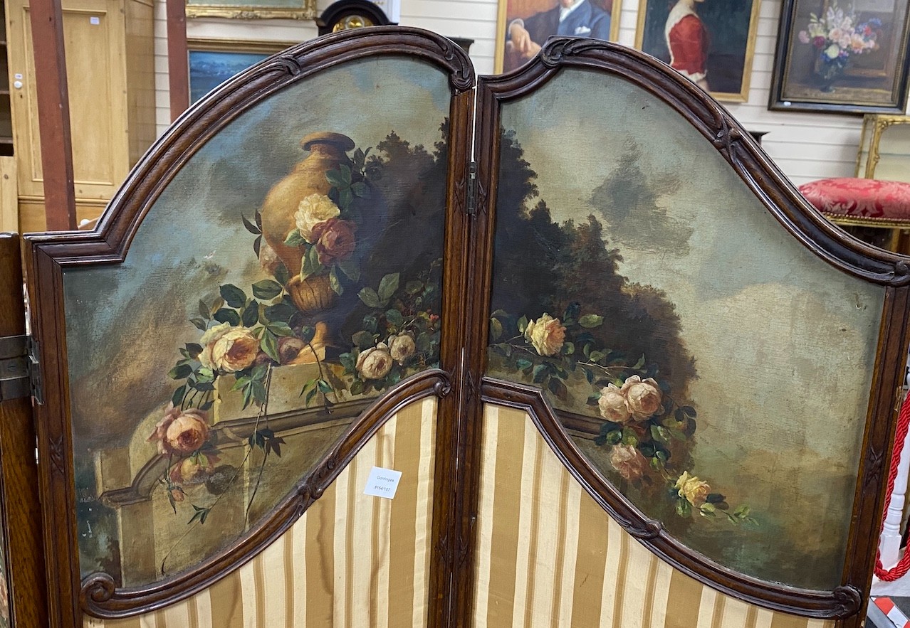 An early 20th century oak three fold screen, painted oil on canvas panels and stretched silk, height 154cm